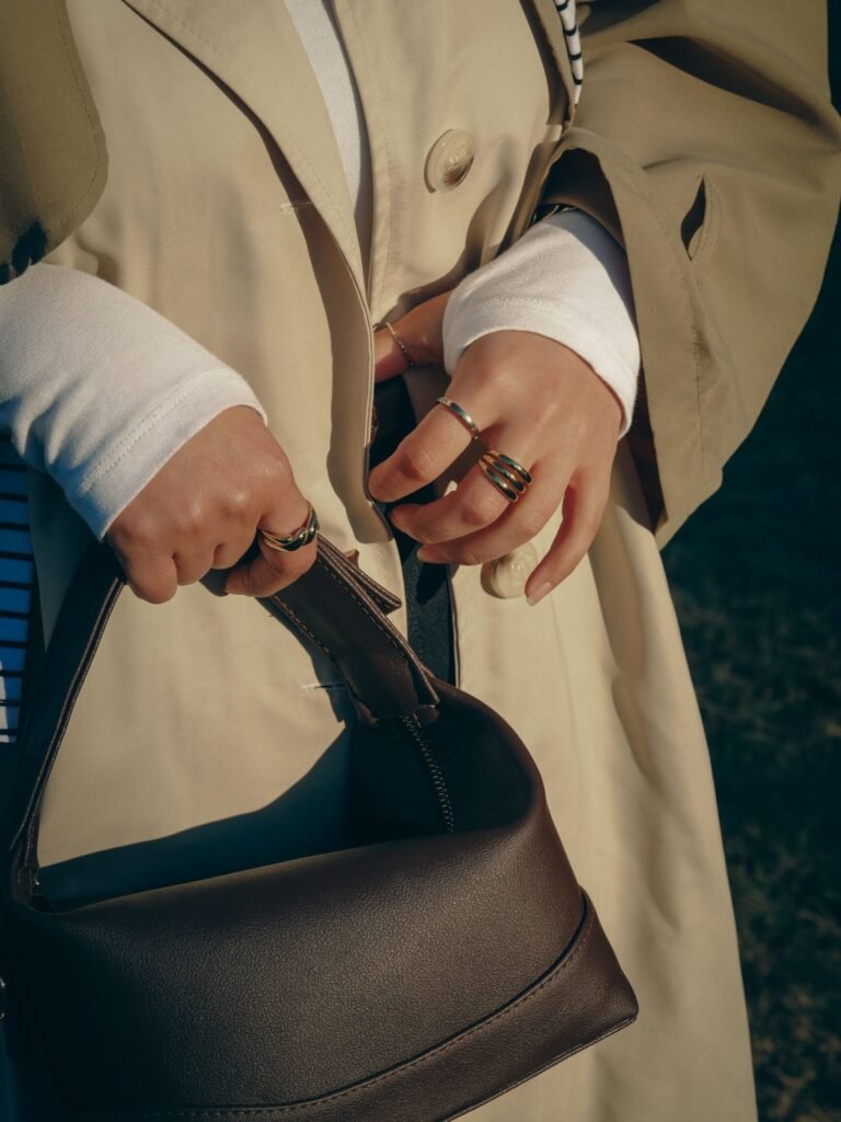 Woman holding a black handbag in a neutral outfit